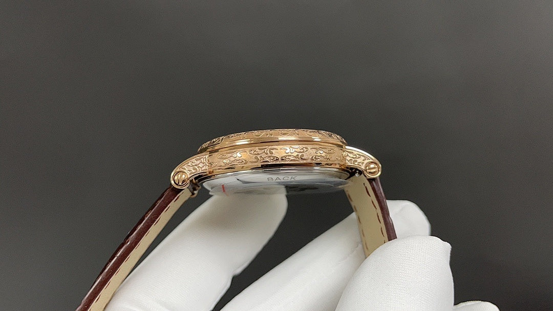Patek Philippe watch case close-up with gold bezel and crown, brown leather strap.
