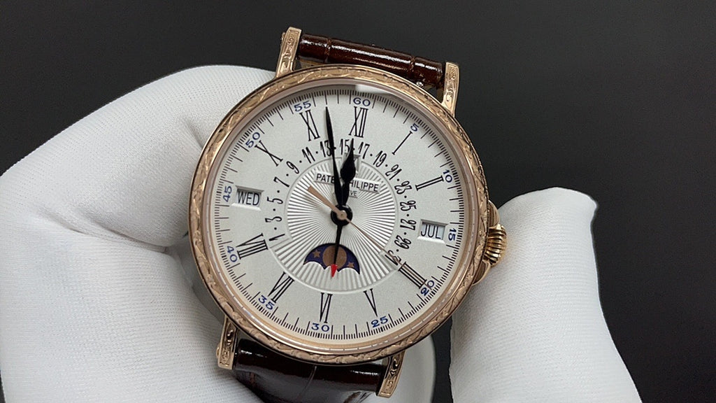Patek Philippe watch front view with white dial, gold case, brown leather strap.