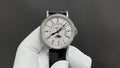 Patek Philippe wristwatch with white dial, Roman numerals, black leather strap