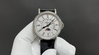 Patek Philippe wristwatch with white dial, Roman numerals, black leather strap