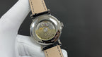 Patek Philippe watch caseback with exposed gears and engraved medallion, black strap
