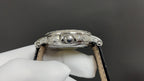 Patek Philippe watch crown and lugs on silver case, black leather strap