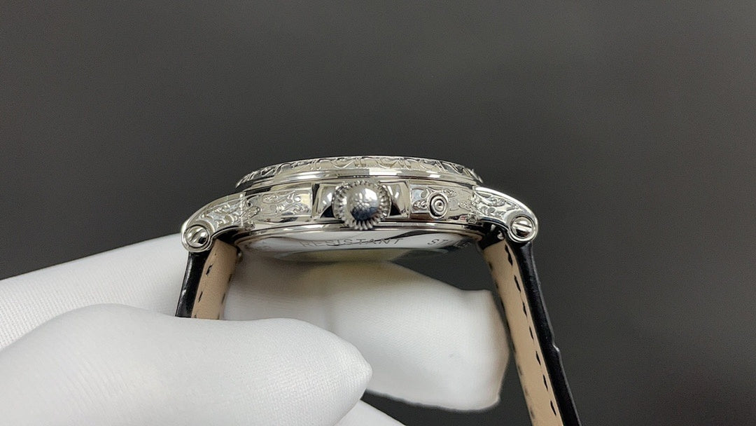 Patek Philippe watch crown and lugs on silver case, black leather strap