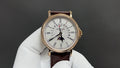 Patek Philippe wristwatch with white dial, gold case, dark brown leather strap