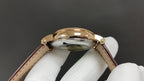 Patek Philippe watch case back view, glossy gold back, dark brown leather strap