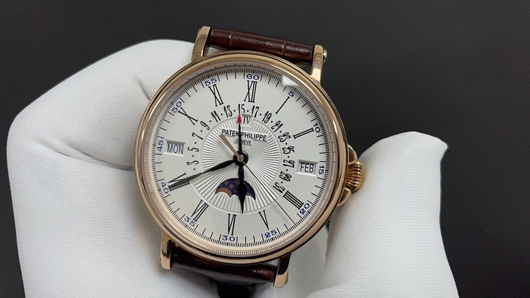 Patek Philippe wristwatch with white dial, gold case, dark brown leather strap on glove