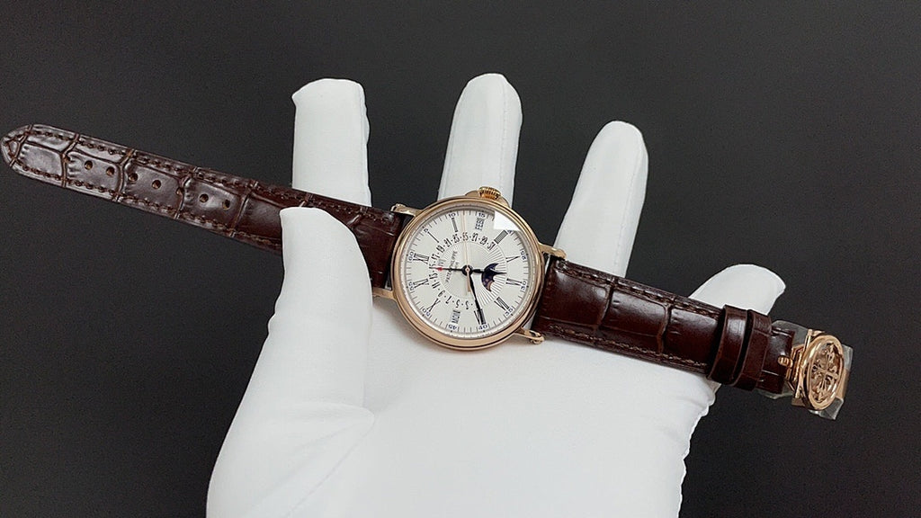 Patek Philippe wristwatch with white dial, dark brown leather strap and gold clasp
