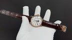 Patek Philippe wristwatch with white dial, dark brown leather strap and gold clasp