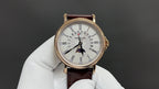 Patek Philippe wristwatch front view with white dial, gold case, dark brown leather strap