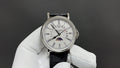 Patek Philippe watch with white dial, silver case, black leather strap and subdials