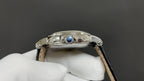 Patek Philippe watch crown-side view with blue detail and polished silver case