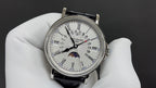 Patek Philippe watch with white dial, silver bezel, black leather strap and moonphase