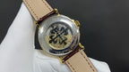 Patek Philippe wristwatch with see-through caseback, decorative movement detail, brown leather strap