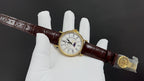 Patek Philippe wristwatch with brown leather strap, clasp detail and small white dial face