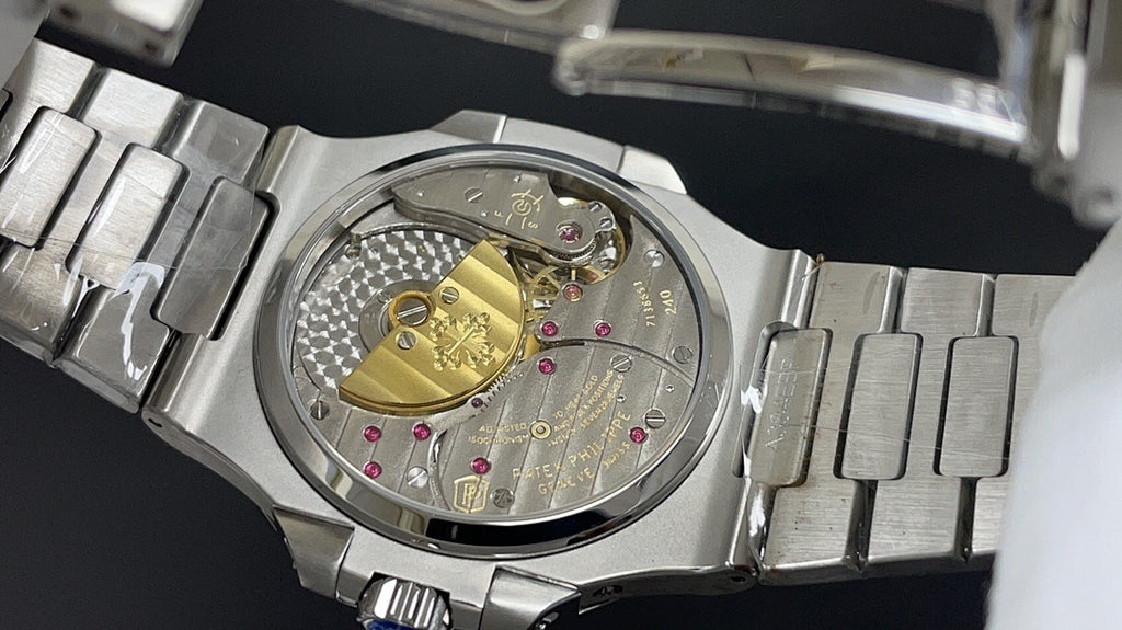Close-up of metal bracelet and watch case with visible movement and jewel details