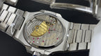 Close-up of metal bracelet and watch case with visible movement and jewel details
