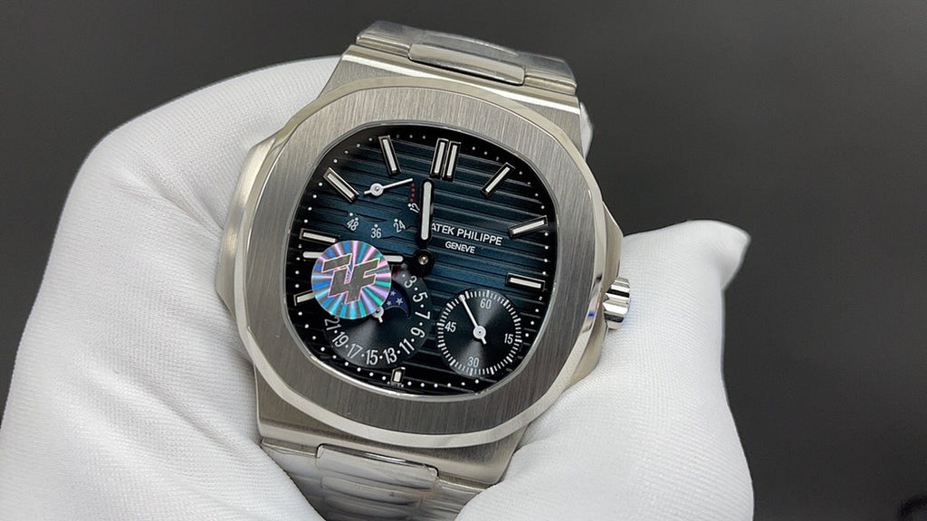 Steel wristwatch with black dial, colored center motif, and visible subdials on bracelet