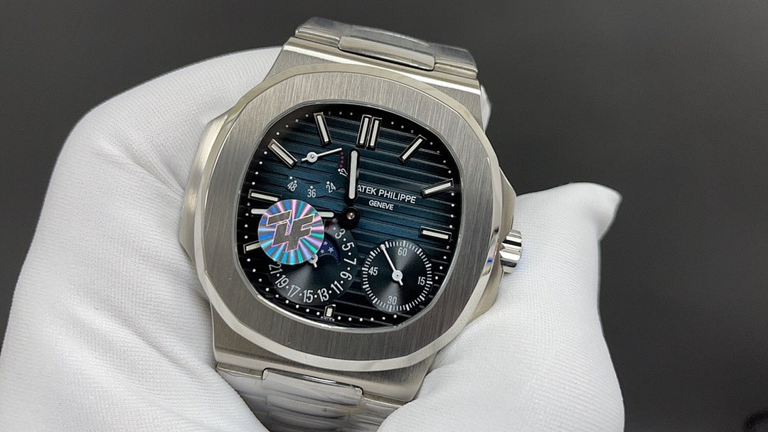 Steel wristwatch with black dial, colored center motif, and visible subdials on bracelet