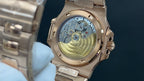Gold-tone wristwatch with open caseback showing mechanical movement