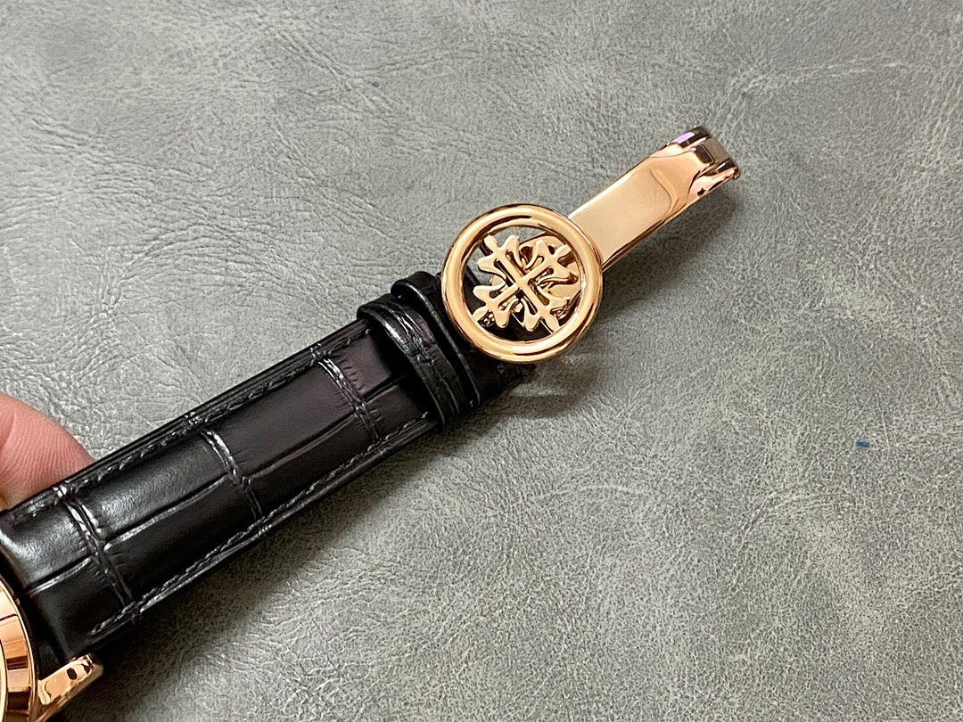 Rose-gold watch crown with engraved emblem on black leather strap