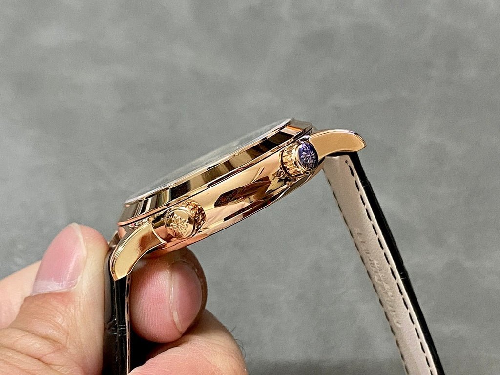 Luxury wristwatch side view with rose-gold case, black leather strap, and crown detail