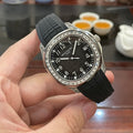 Patek Philippe watch with black dial, black rubber strap, and jeweled silver bezel