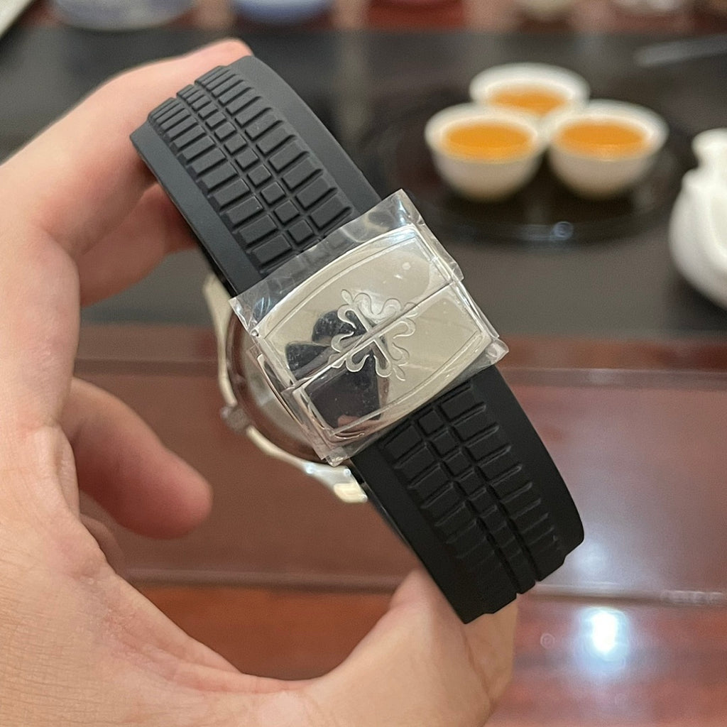 Patek Philippe watch with black rubber strap, angled view, and clasp detail