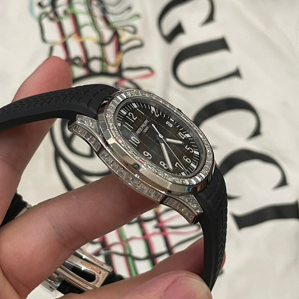 Patek Philippe wristwatch with black dial and black rubber strap, silver bezel detail