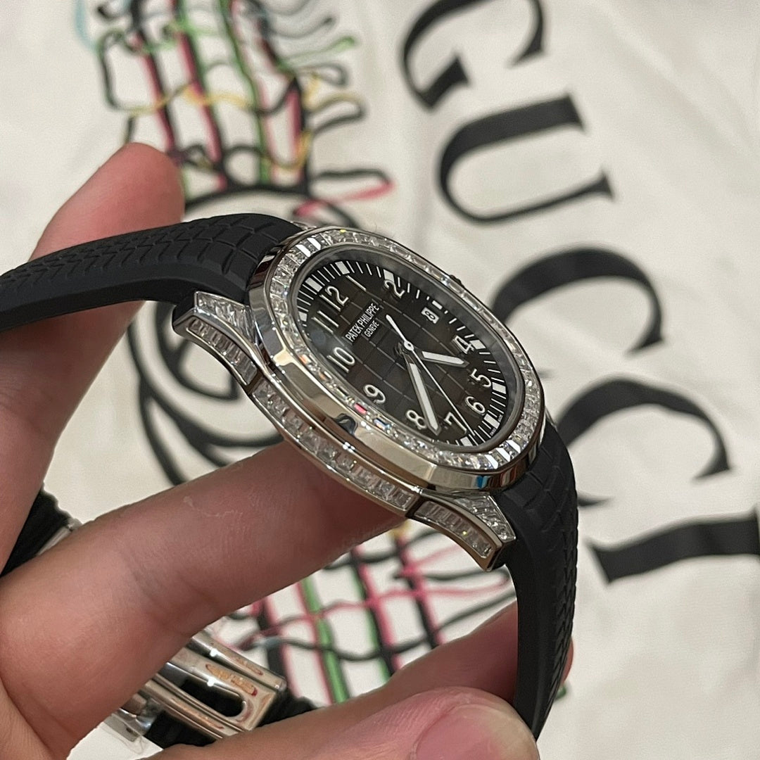 Patek Philippe wristwatch with black dial and black rubber strap, silver bezel detail