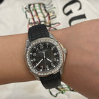 Patek Philippe wristwatch front with black dial, black rubber strap, silver bezel stones