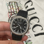 Patek Philippe wristwatch front view with black dial, black rubber strap and diamond bezel