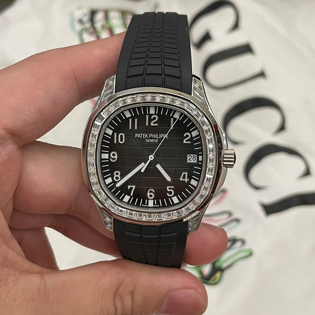 Patek Philippe wristwatch with black dial, black rubber strap, silver bezel and date window