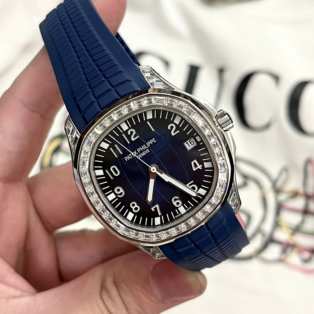 Luxury wristwatch with blue rubber strap, black dial, and diamond-studded bezel