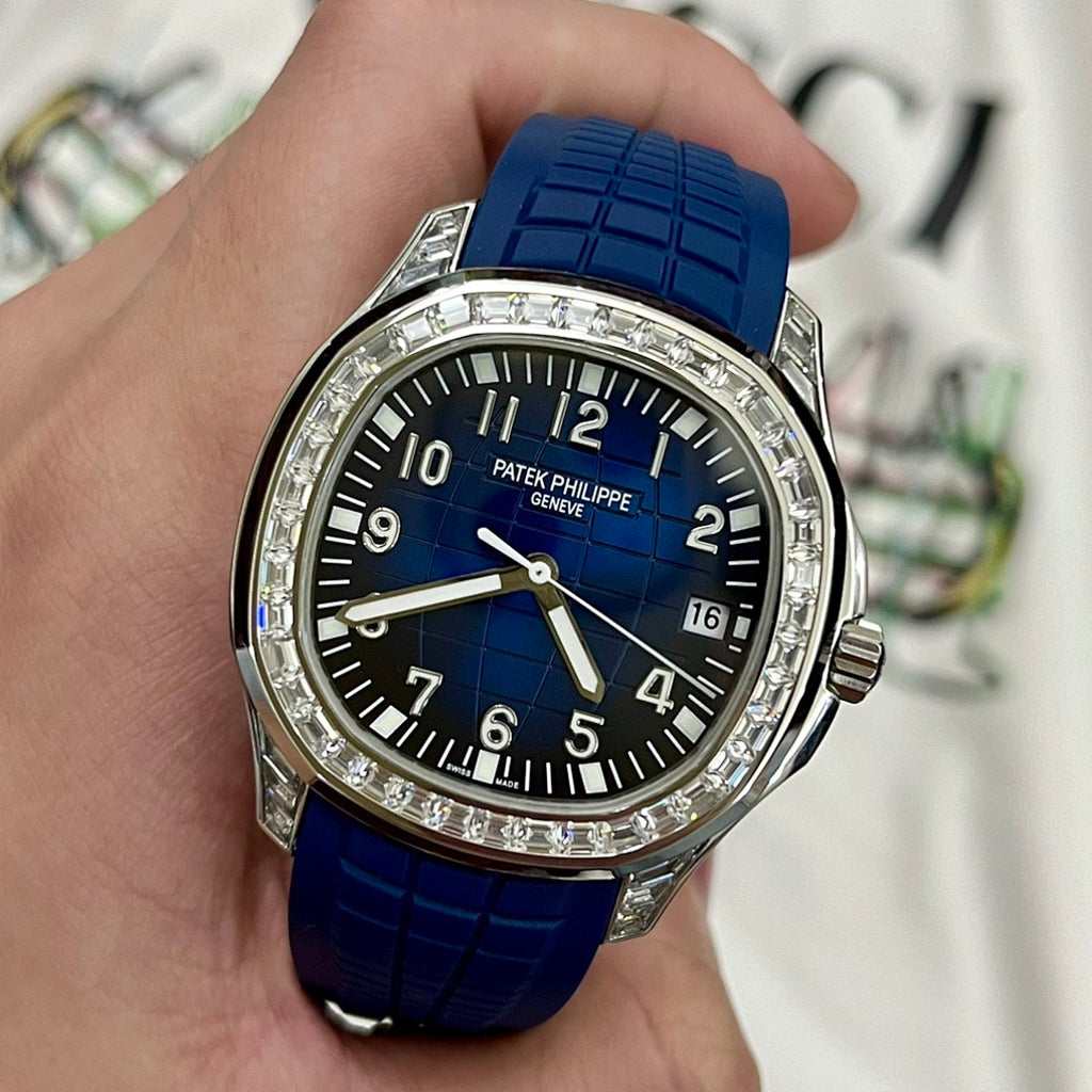 Round luxury watch with blue dial, diamond bezel, and blue rubber strap