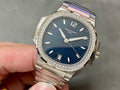 Patek Philippe wristwatch with blue dial and diamond bezel on metal bracelet