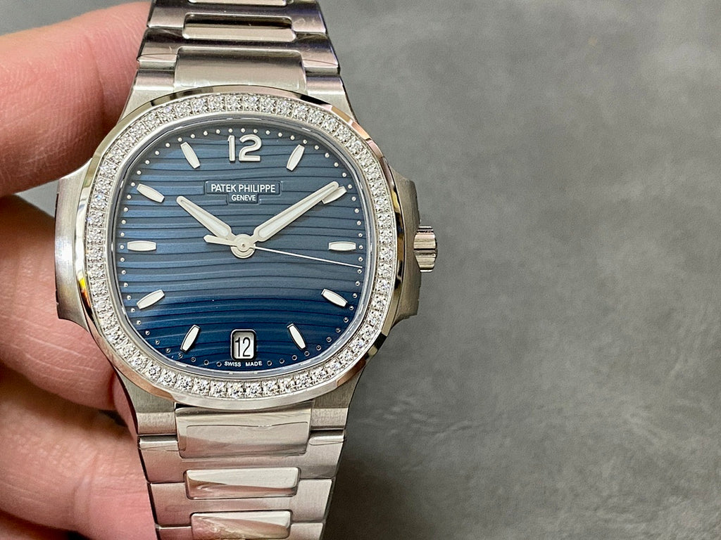 Patek Philippe wristwatch front view with blue dial, diamond-set bezel, steel bracelet