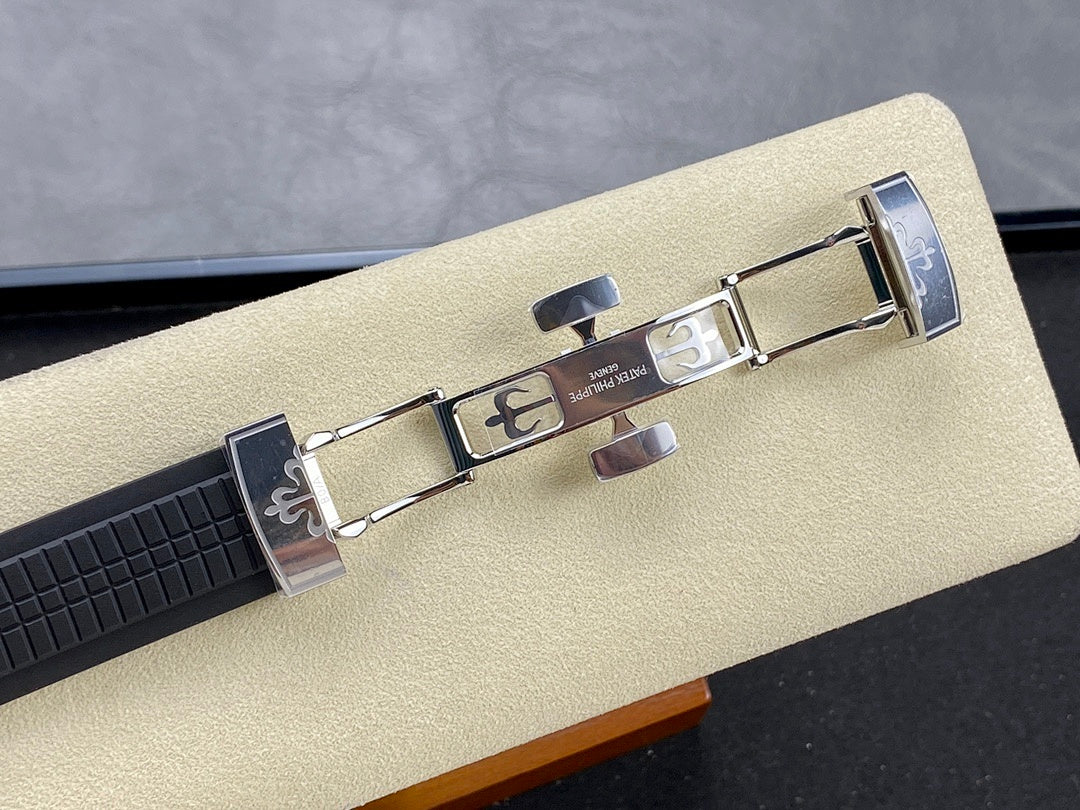 Patek Philippe watch clasp with metal buckle on black rubber strap.