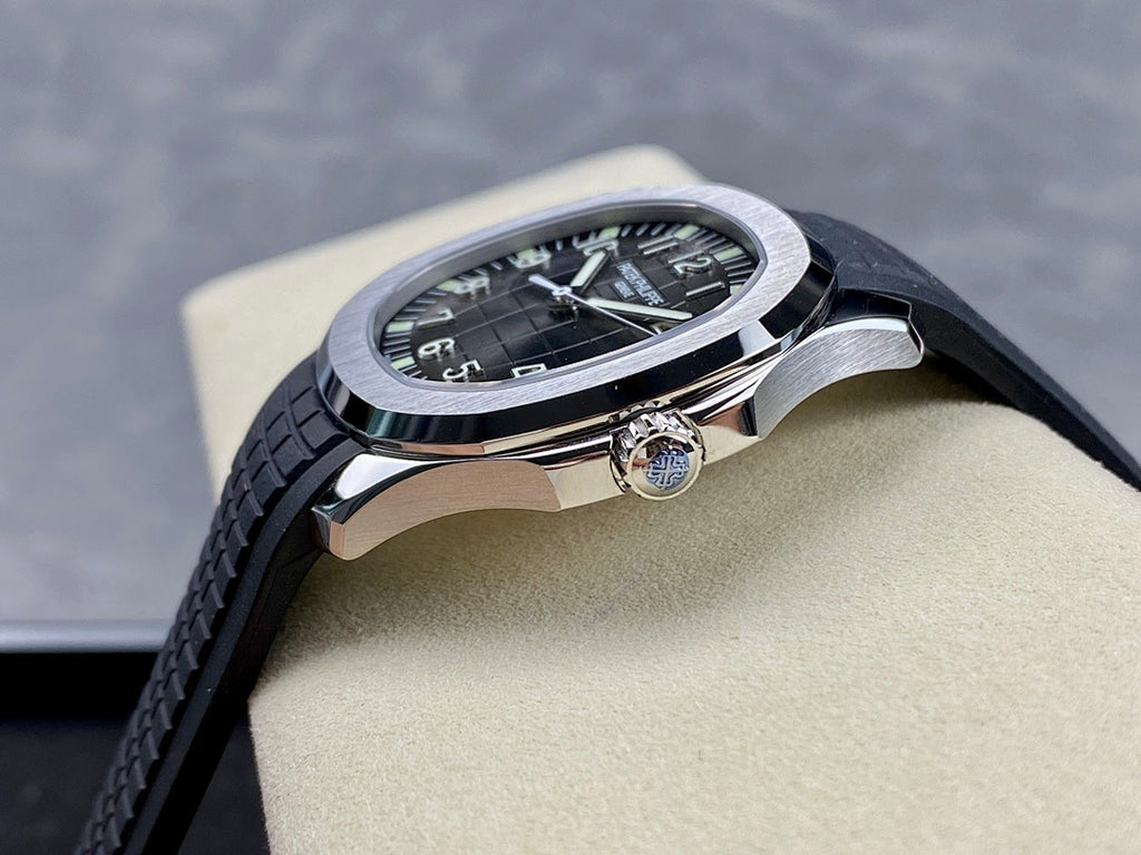 Patek Philippe wristwatch on wrist: black dial, silver case, black rubber strap.