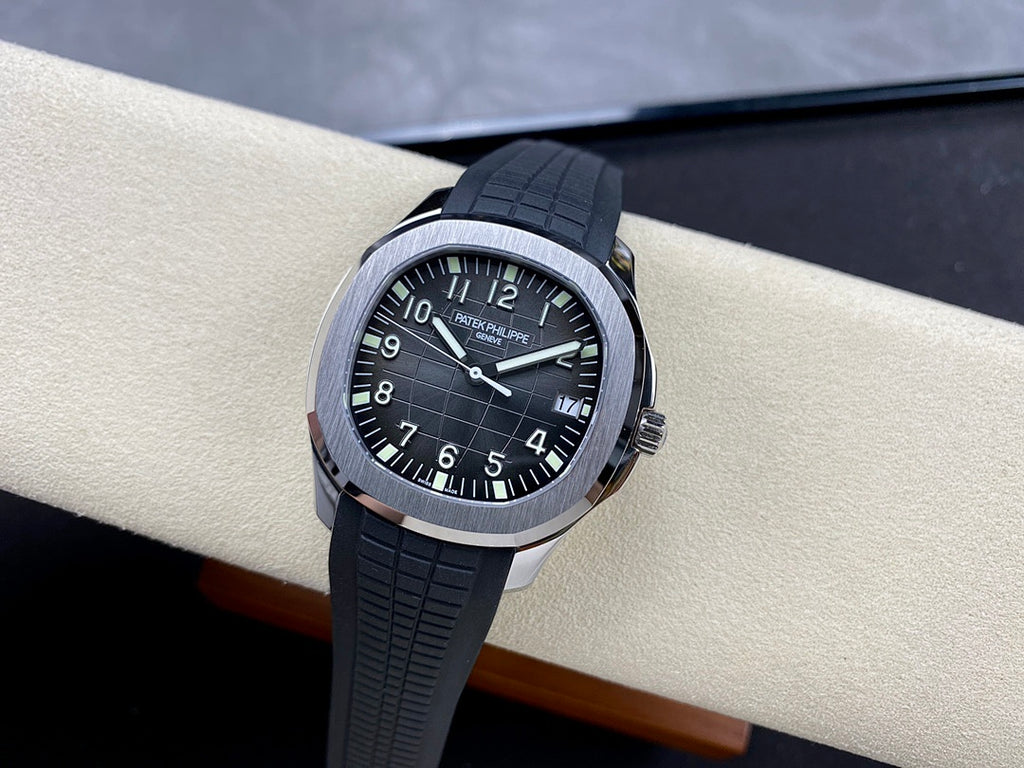 Patek Philippe wristwatch on stand: black dial with luminous markers, black rubber strap.