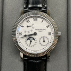 Patek Philippe watch with white dial, black leather strap, textured jeweled bezel
