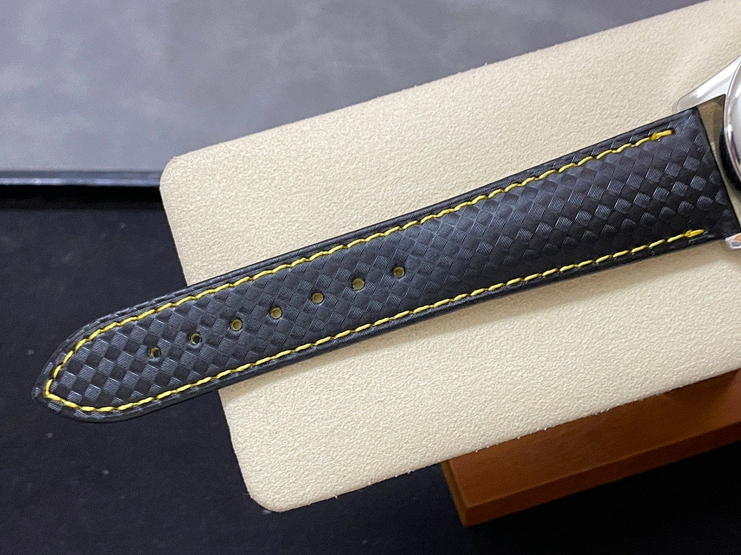Black watch strap with subtle texture and bright yellow contrast stitching.