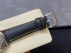 Black textured watch strap with yellow contrast stitching and metal buckle clasp.