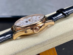 Patek Philippe watch side view with crown and rose-gold case on black leather strap