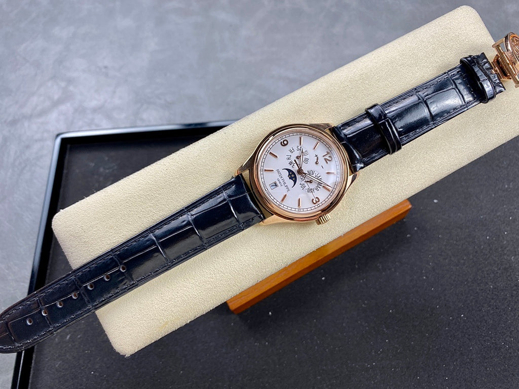Patek Philippe watch on black leather strap with rose-gold case and white dial