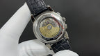 Patek Philippe watch caseback with see-through movement and black leather strap