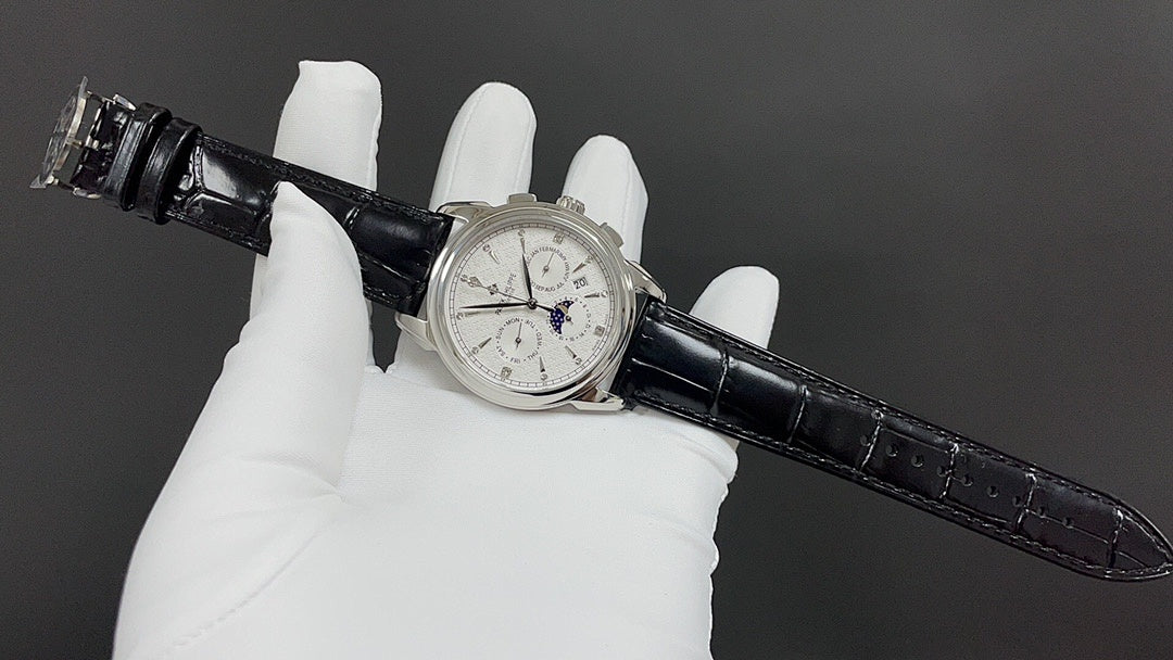 Patek Philippe watch on black leather strap held by white-gloved hands