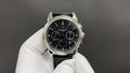 Patek Philippe chronograph watch with black dial, steel case, and black leather strap