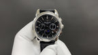 Patek Philippe chronograph watch with black dial, steel case, and black leather strap
