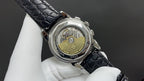 Patek Philippe watch caseback with visible movement and black leather strap