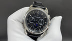 Patek Philippe chronograph watch with black dial and black leather strap, steel case
